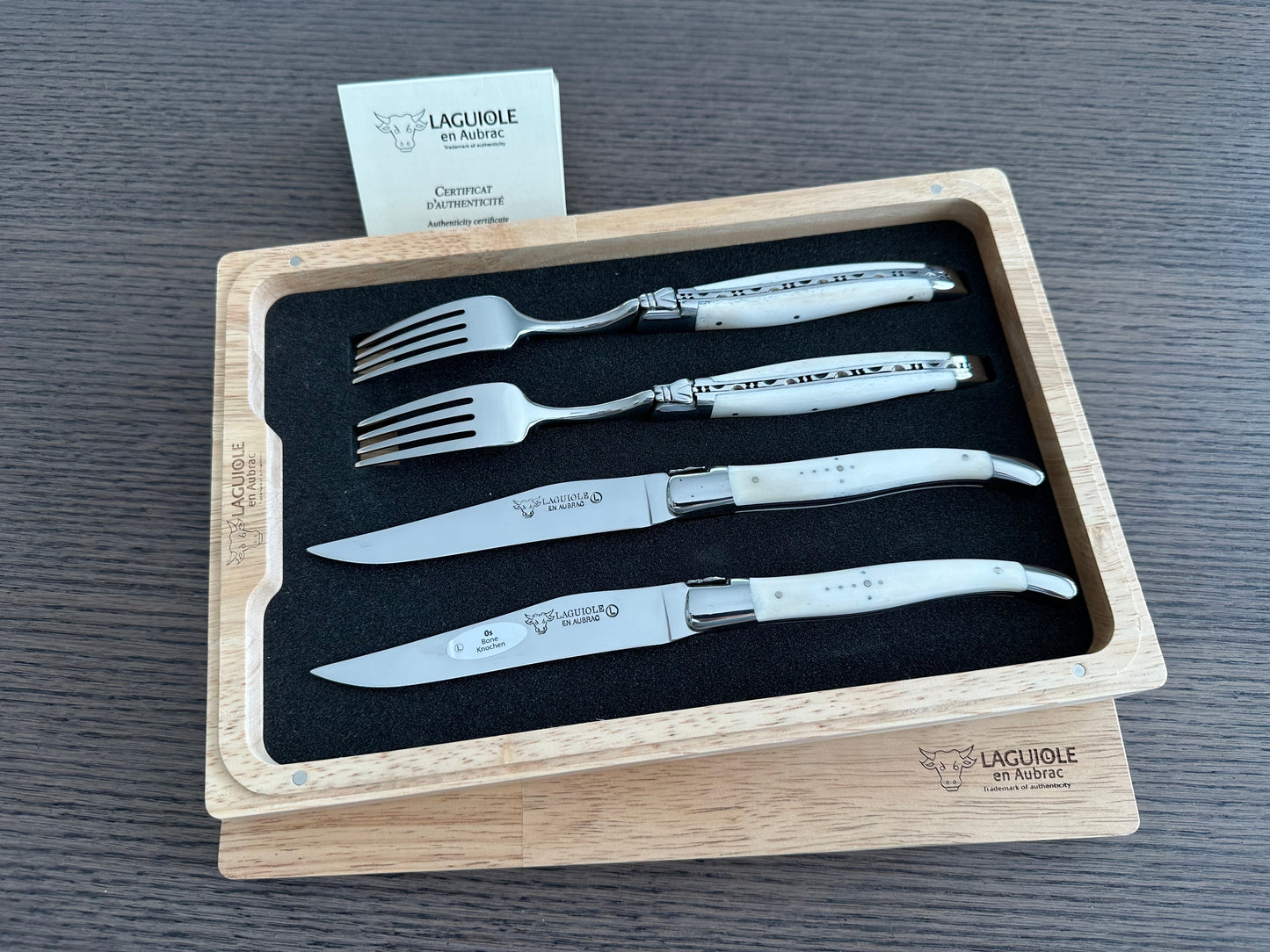 Laguiole en Aubrac Handcrafted 4-Piece Set With 2 Steak Knives and 2 Forks With Zebu Bone Handles, Polished Bolsters