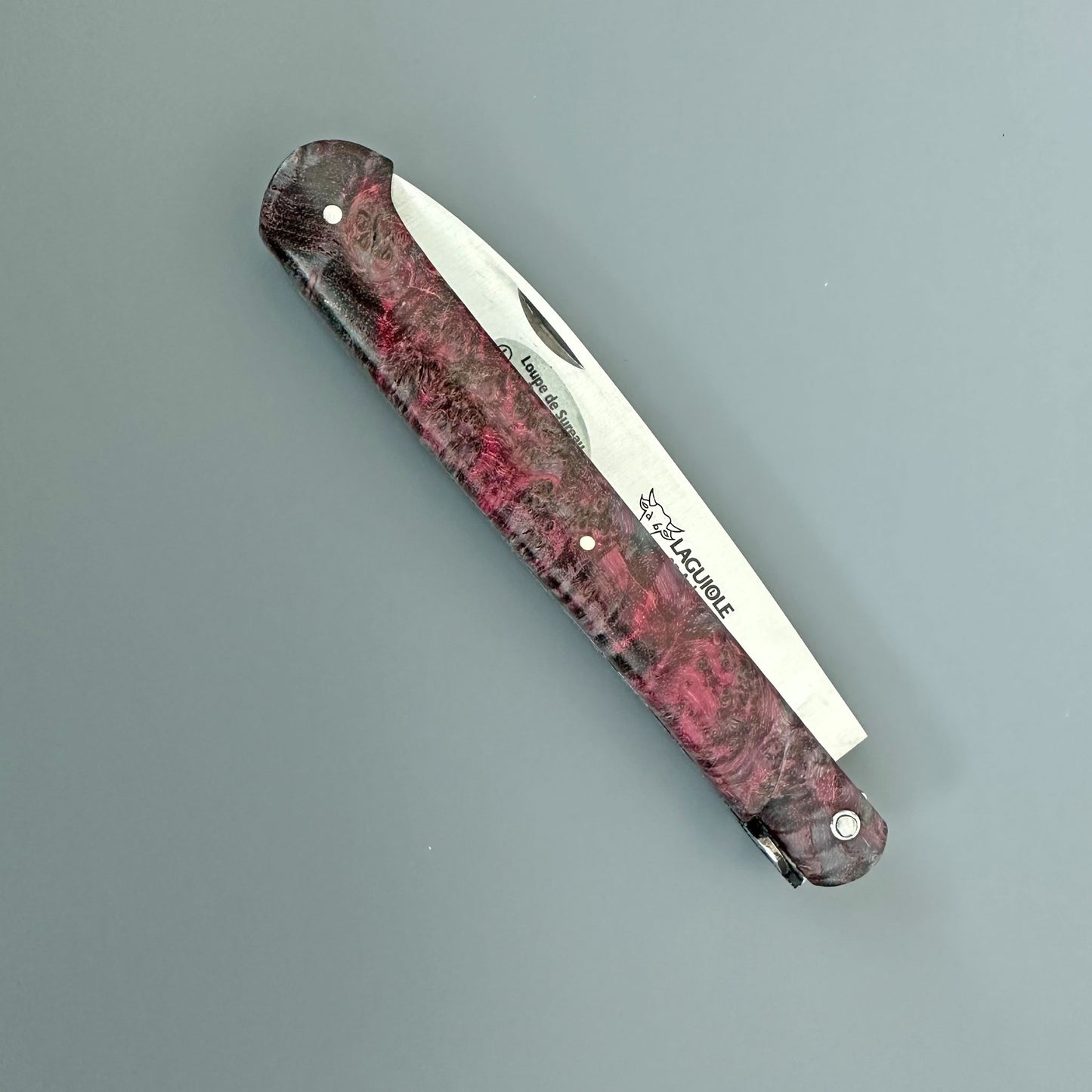 A folding pocket knife with a marbled reddish-brown in closed position.