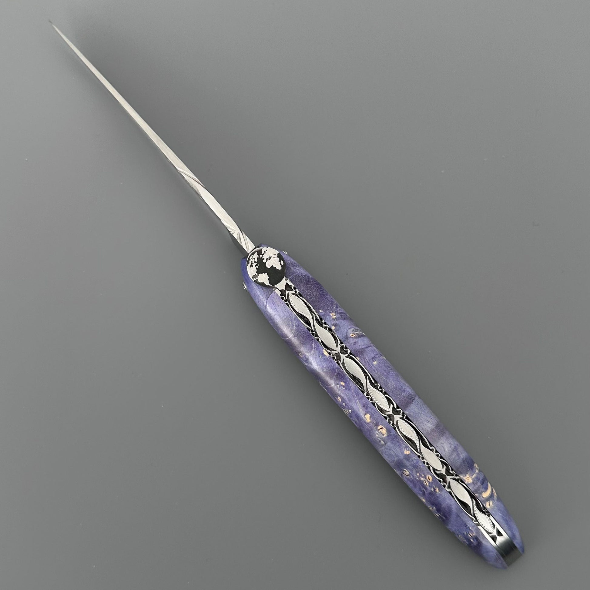 Laguiole en Aubrac pocket knife with  a marbled purple handle featuring silver filigree patterns 