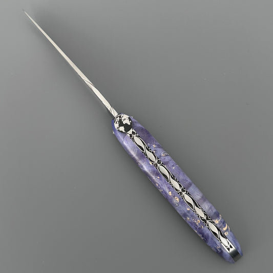 Laguiole en Aubrac pocket knife with  a marbled purple handle featuring silver filigree patterns 