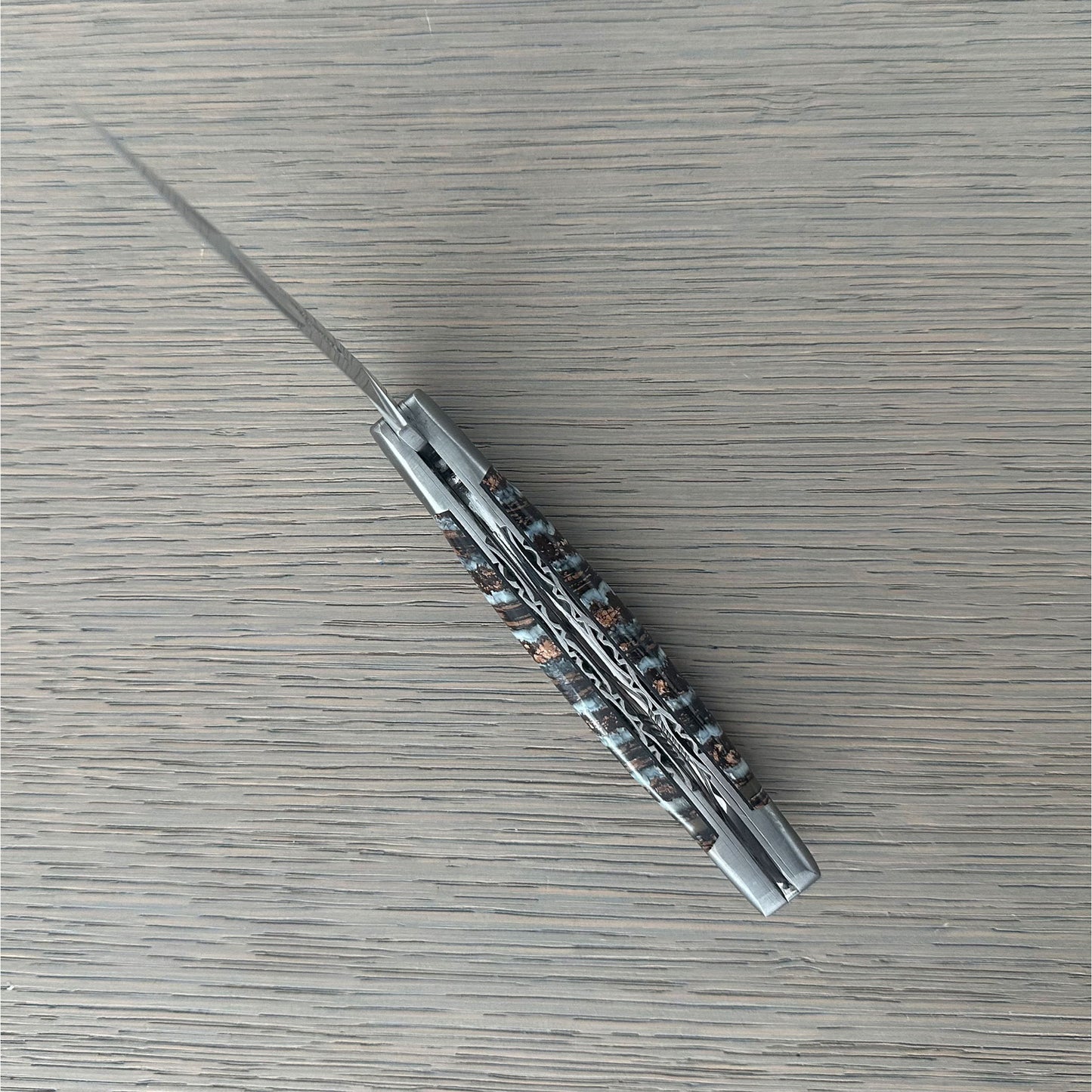 Intricate hand-filework on the double-plated construction of a Laguiole en Aubrac folding knife.