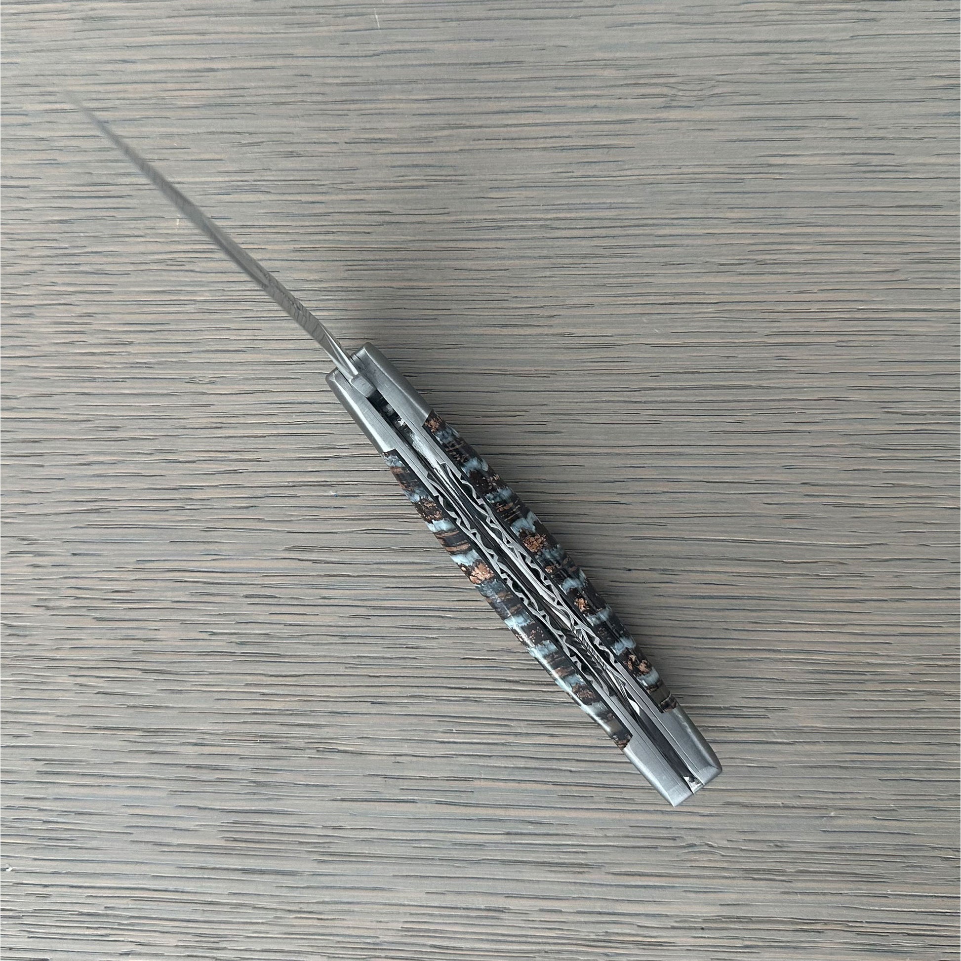 Intricate hand-filework on the double-plated construction of a Laguiole en Aubrac folding knife.