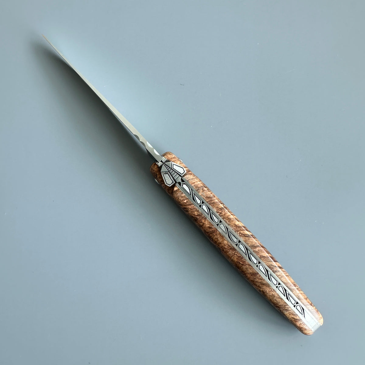 Cenital view of Laguiole en Aubrac folding knife with Amboyna burl wood handle