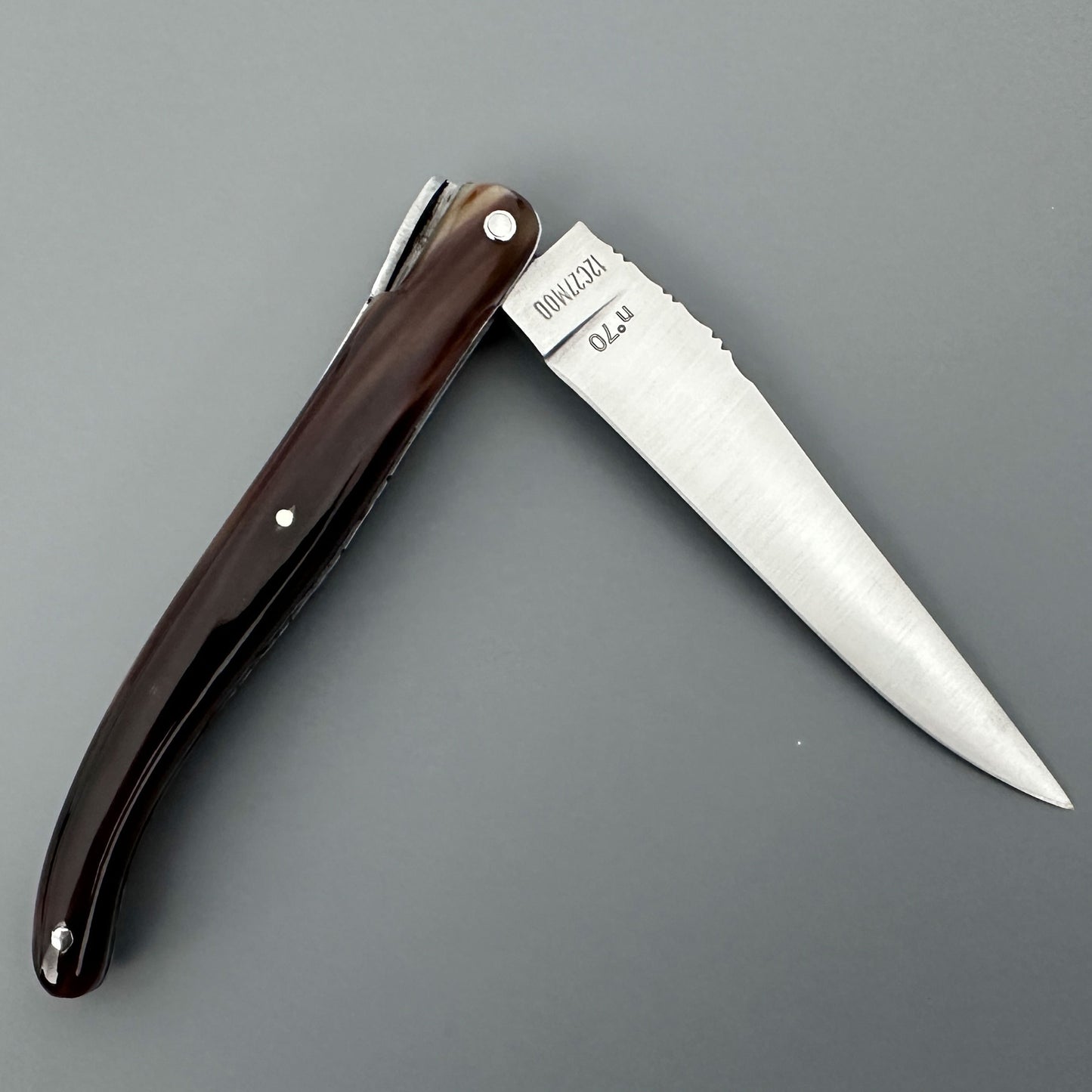 Reverse view of an open Laguiole en Aubrac Origine Tour Eiffel folding knife with solid horn handle