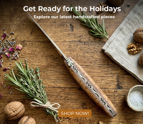 Laguiole en Aubrac knife on a wooden table with rosemary