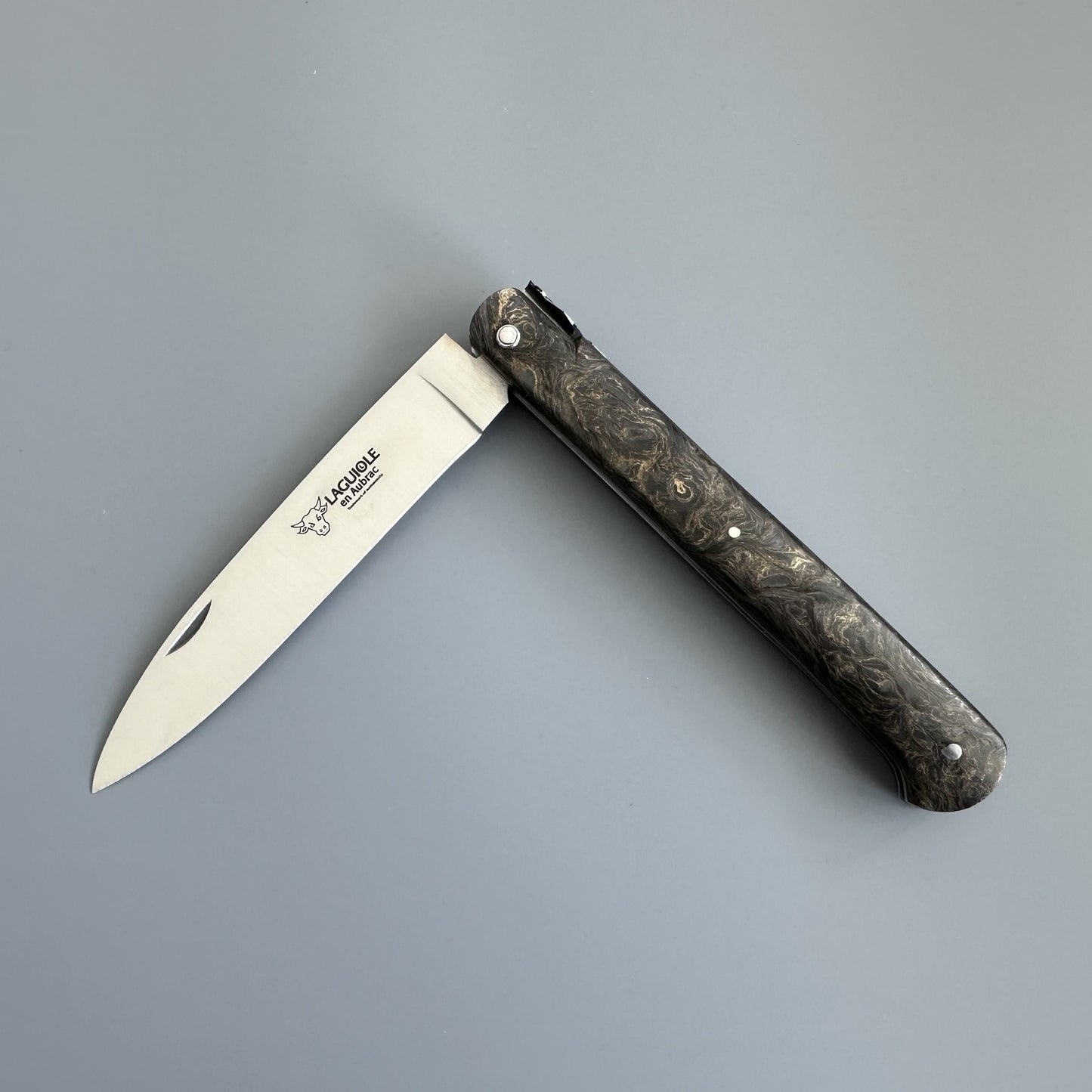 Laguiole Droit folding knife with dark burl handle, shown open on a gray background, showcasing its straight silhouette