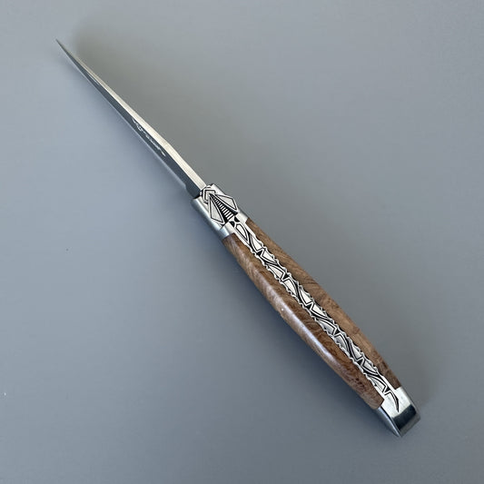 Laguiole en Aubrac knife open, angled to show the special hand-carved bee and geometric silver inlay along the teak handle