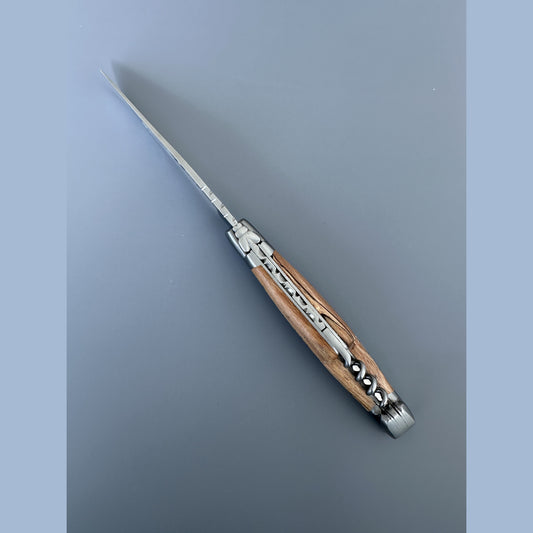 A folding pocket knife with a silver stainless steel blade and a dual-tone wood and metal handle, shown on a solid gray background.