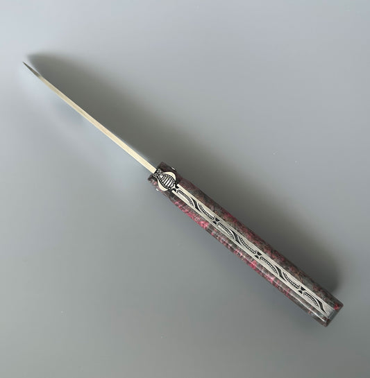 A folding pocket knife with a silver stainless steel blade and a textured handle featuring a pink and gray pattern with silver engraved details, shown on a neutral gray background.