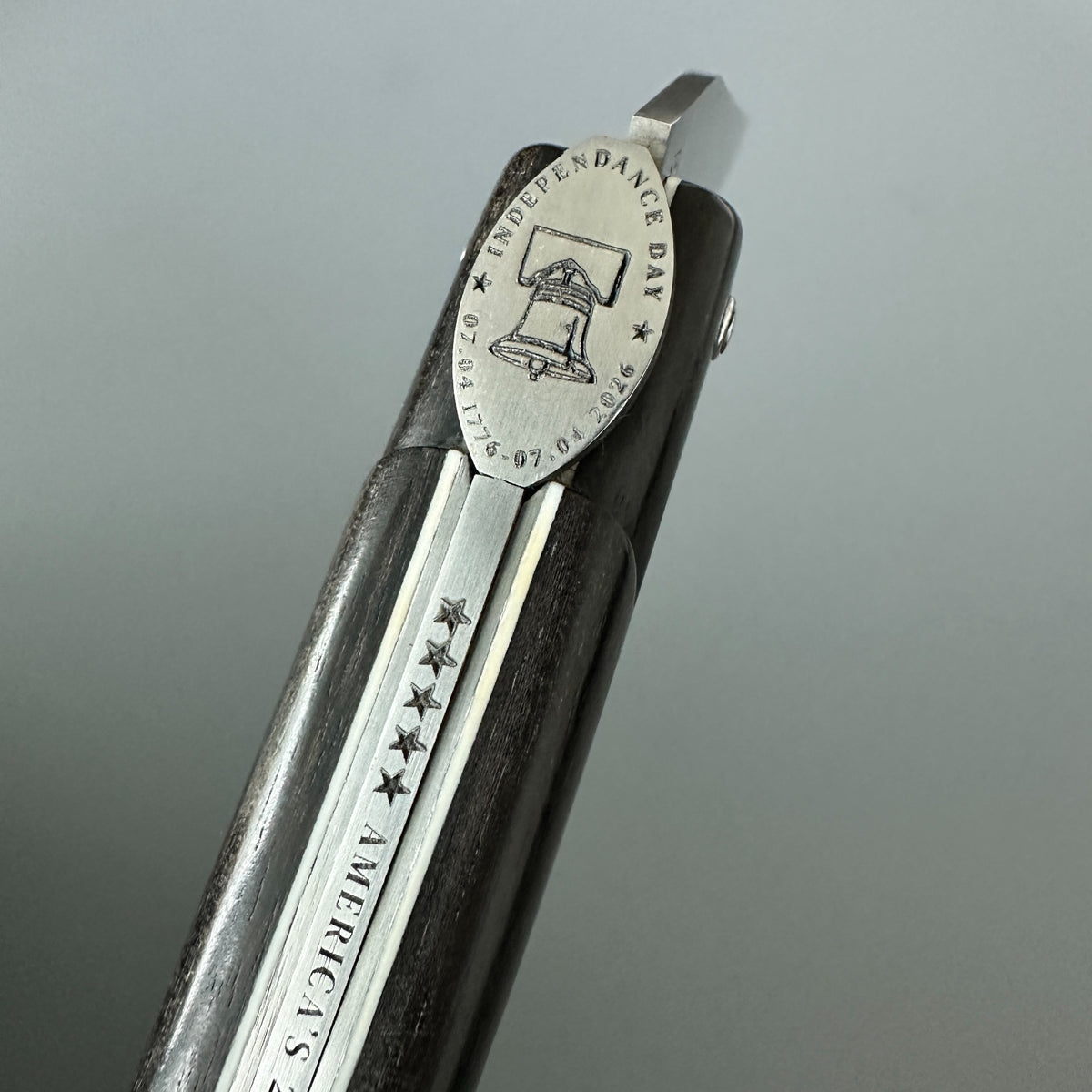 A close-up of a Laguiole en Aubrac USA Independence 250 anniversary folding pocket knife with Ebony Handle