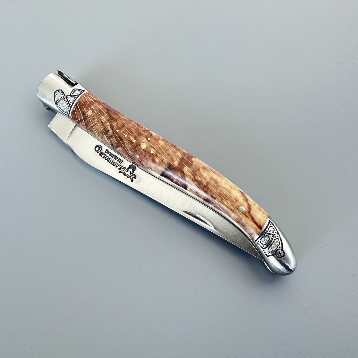 Closed Laguiole en Aubrac Belle knife with Aubrac wood handle, black inlay and guilloché bolsters