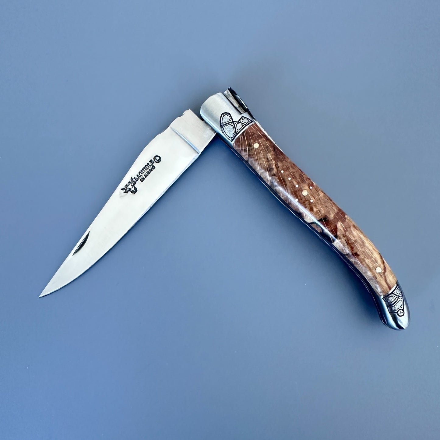 Angled open Laguiole en Aubrac Belle knife with Aubrac wood handle and guilloché bolsters