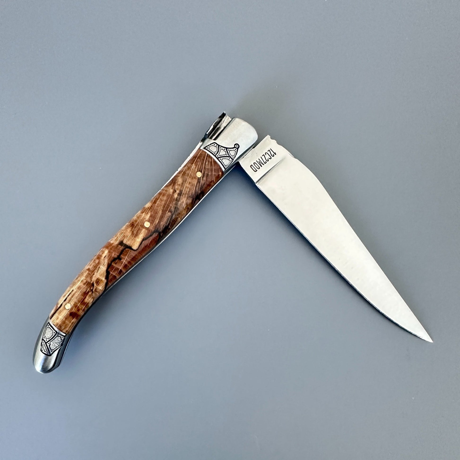 Reverse view of an open Laguiole en Aubrac Belle knife with Aubrac wood handle