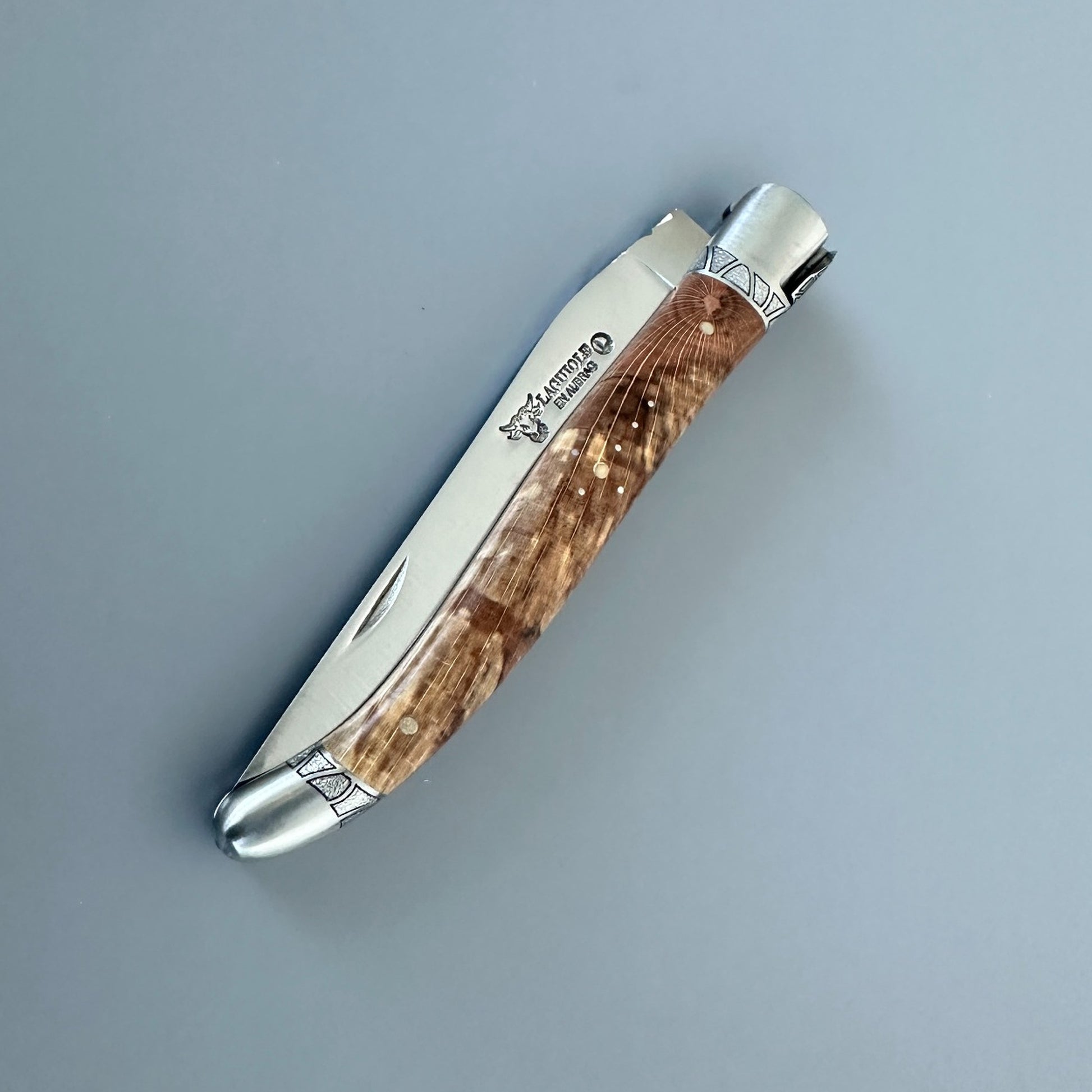 Closed Laguiole en Aubrac Belle knife with Aubrac wood handle, red inlay and engraved bolsters