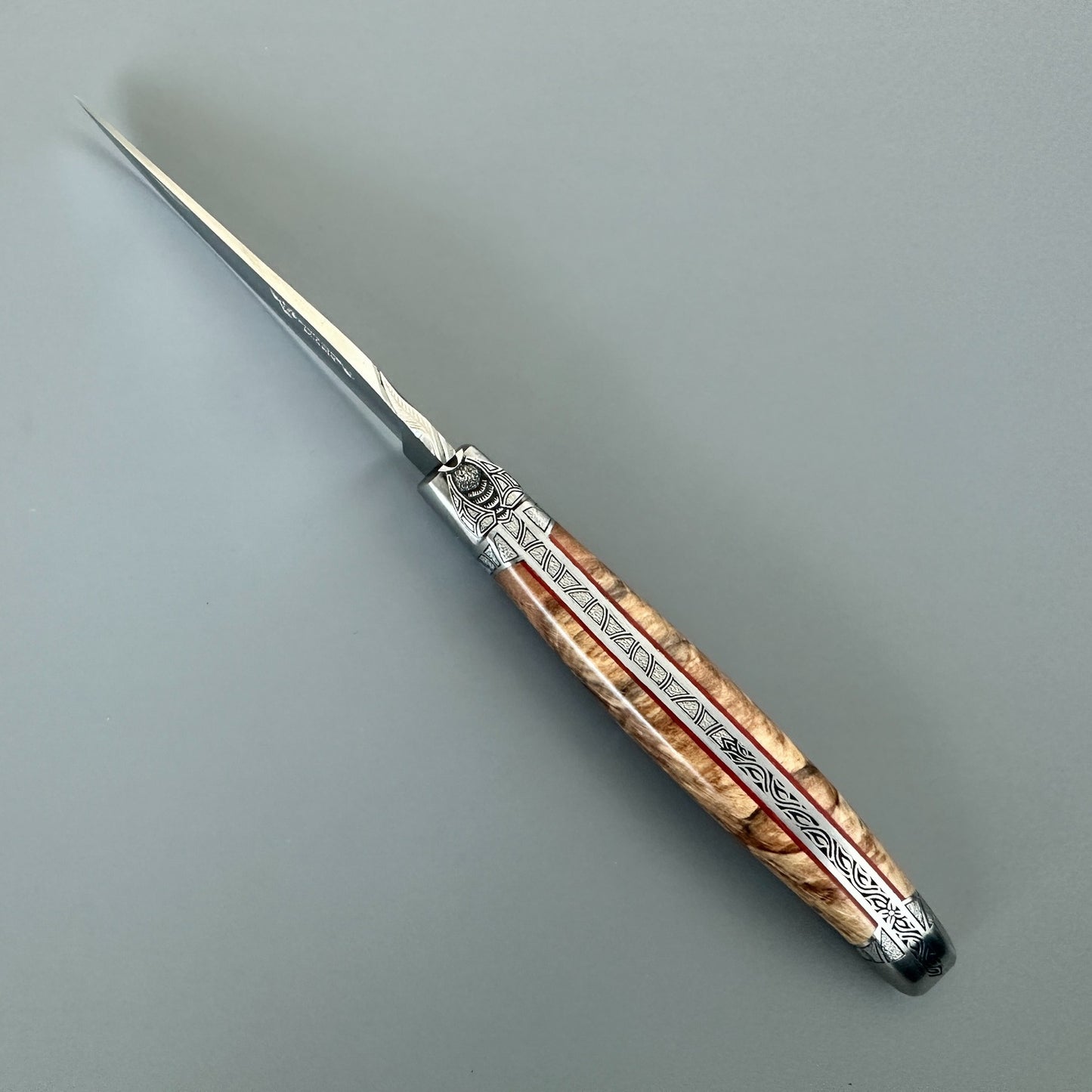 Fully open Laguiole en Aubrac Belle knife showing Aubrac wood, red inlay and guilloché spine