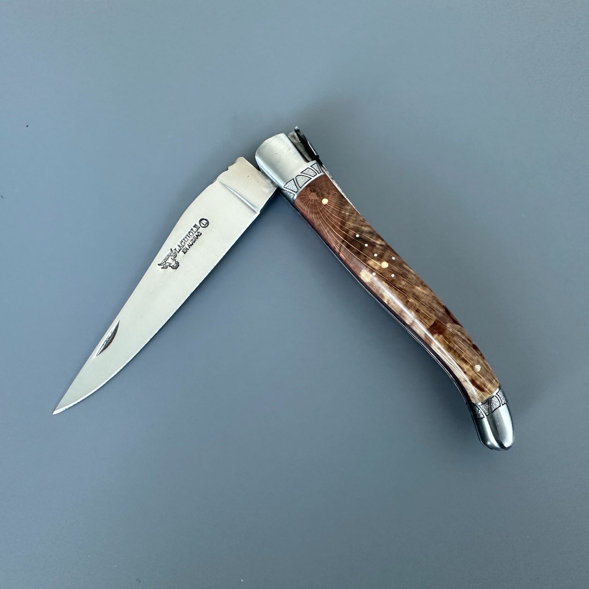 Open Laguiole en Aubrac Belle knife with Aubrac wood handle, red inlay and decorated bolsters