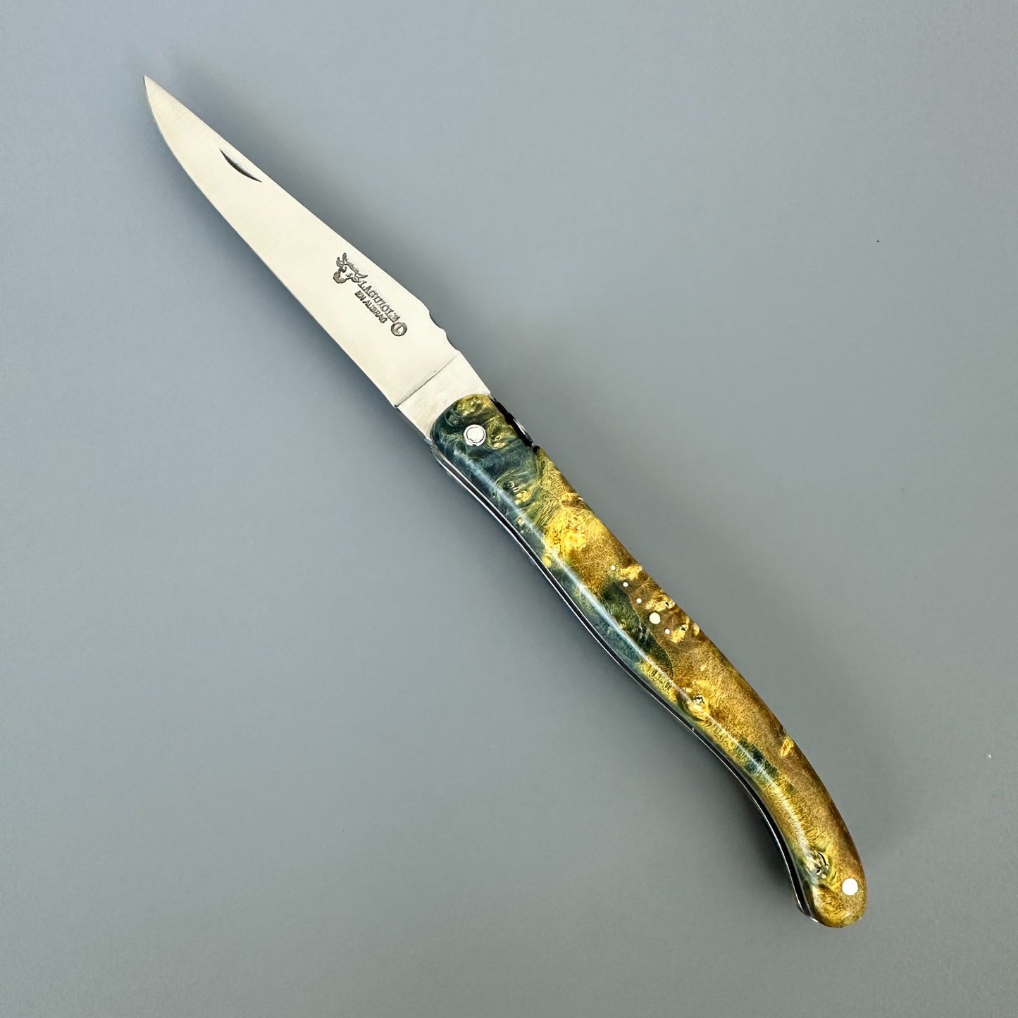Fully open Laguiole en Aubrac Belle folding knife with green and yellow elder burl handle and special bee