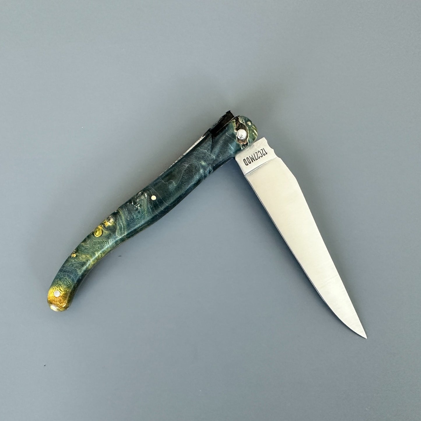Reverse view of an open Laguiole en Aubrac Belle knife with elder burl handle and special bee
