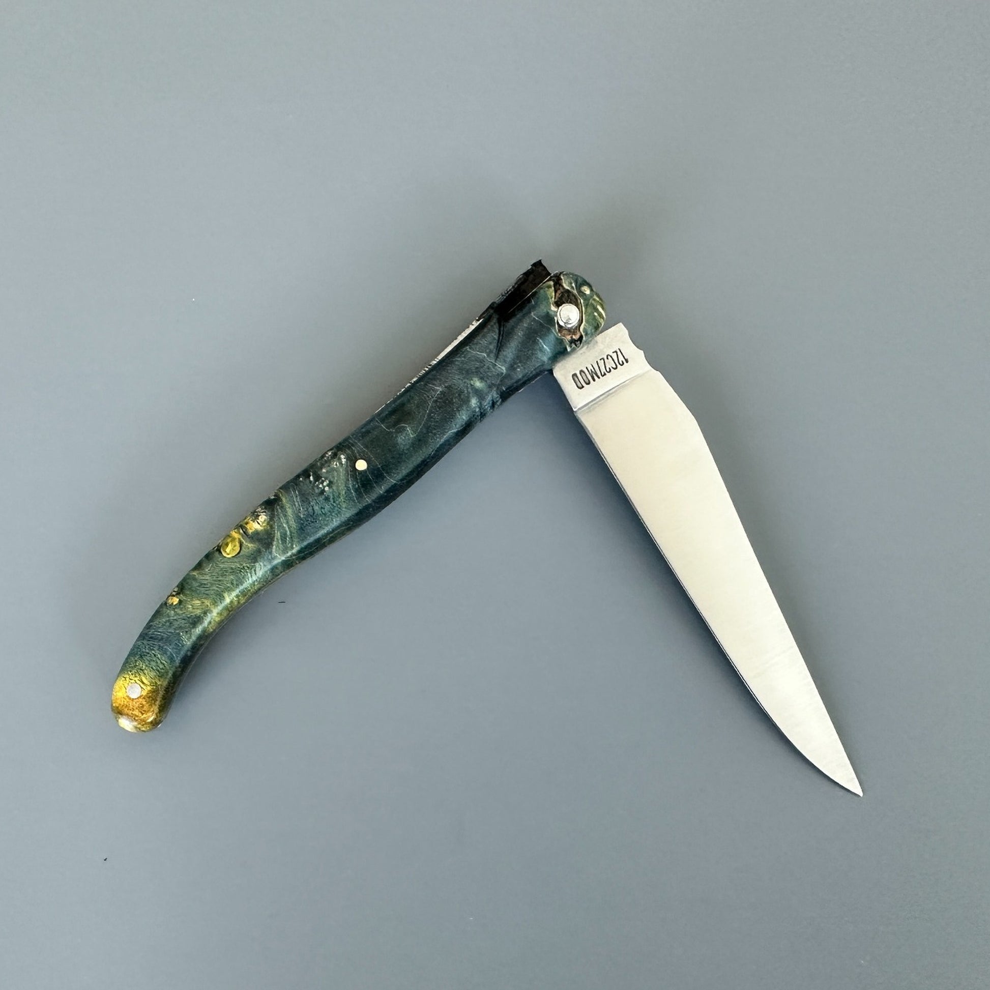 Reverse view of an open Laguiole en Aubrac Belle knife with elder burl handle and special bee