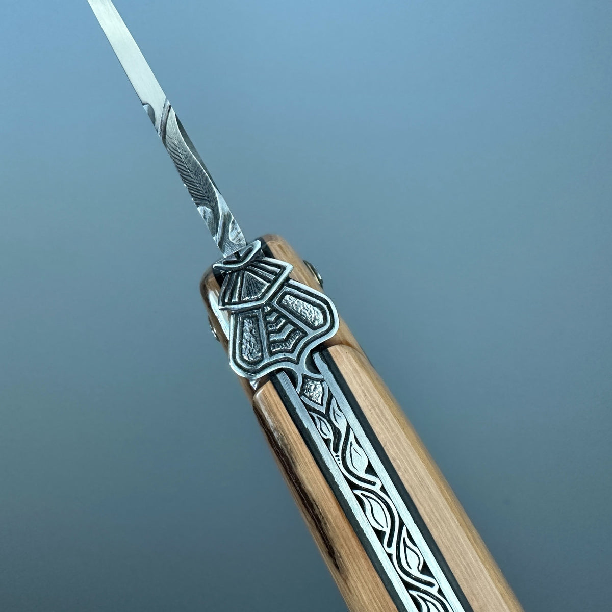 Close-up of the sculpted bee and intricate spine work on the Laguiole en Aubrac Belle Piece