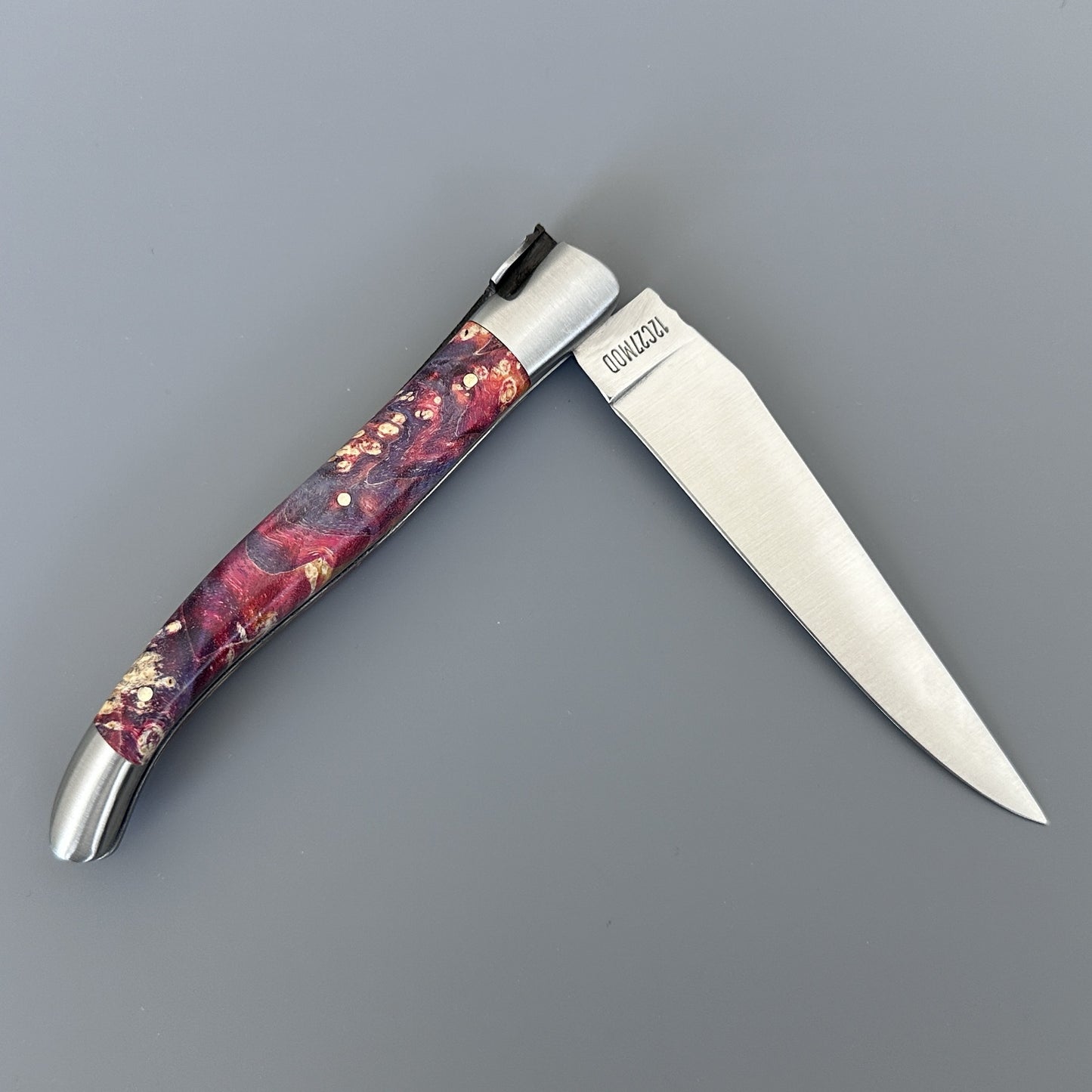 Open Belle knife with polished blade and deep purple-red elder burl handle, shown blade-right