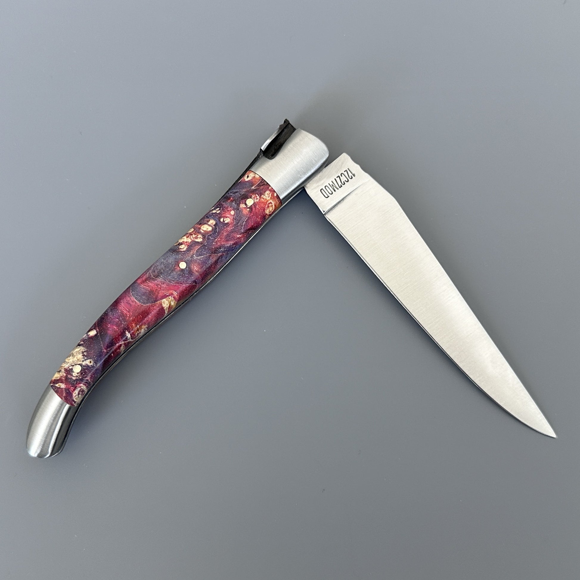 Open Belle knife with polished blade and deep purple-red elder burl handle, shown blade-right