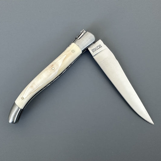 Open Belle folding knife with etched blade and cream bone handle, shown blade-right with maker's mark