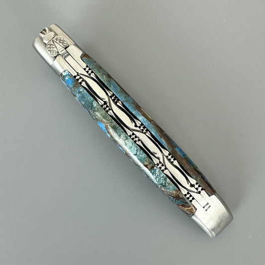 Cenital view of Laguiole en Aubrac Folding Knife with Blue Fusion handle over gray background