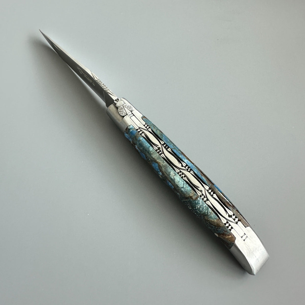 Laguiole en Aubrac pocket knife with a silver steel blade and a decorative handle made of Fusion Blue Mammoth Ivory handle handle.