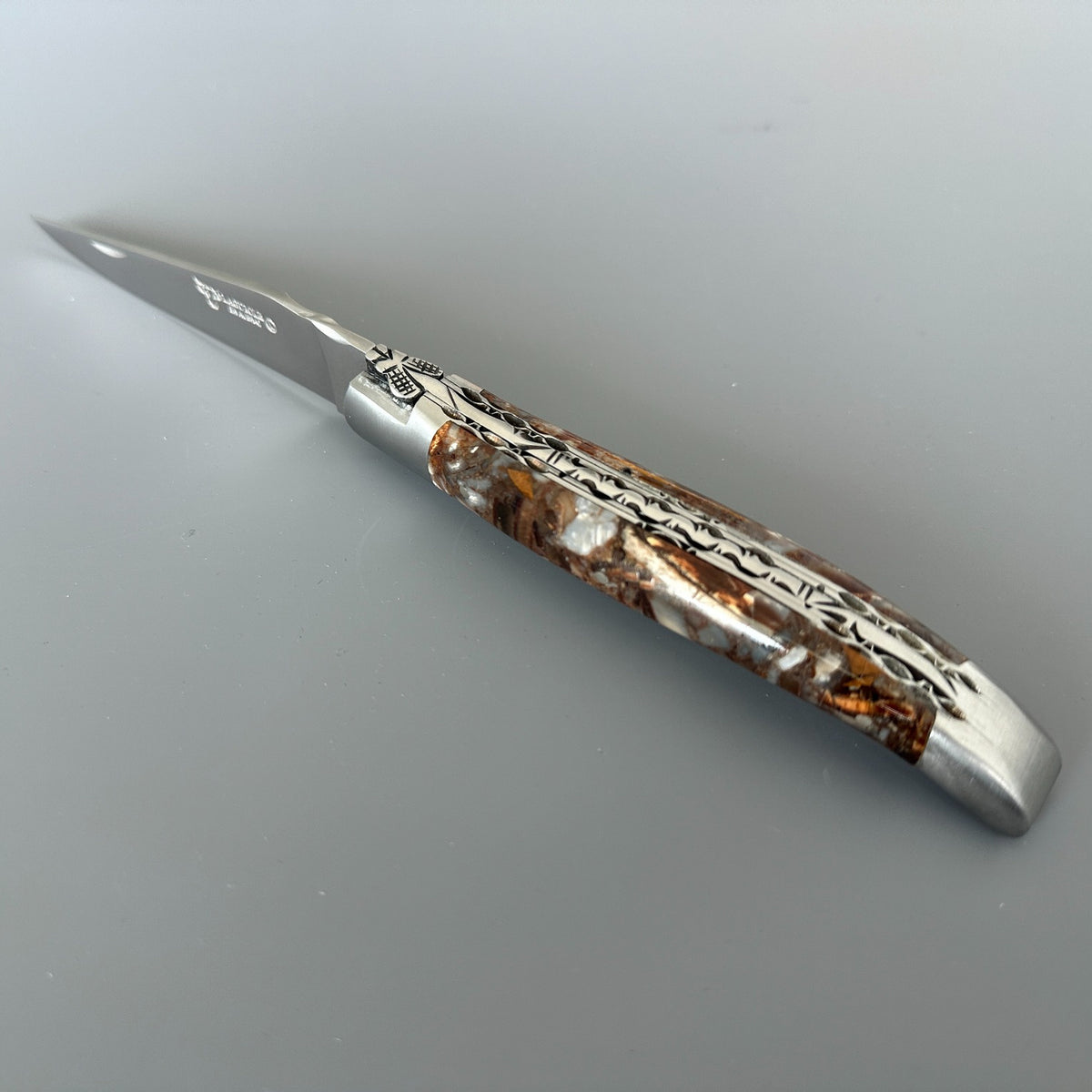 Laguiole en Aubrac pocket knife with a silver steel blade and a decorative handle made of Mammoth handle.