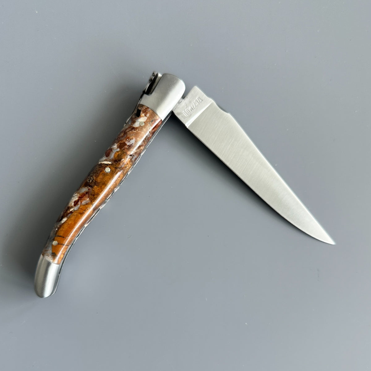 Reverse side of partially open Laguiole en Aubrac Folding Knife with Fusion Mammoth Ivory handle handle.
