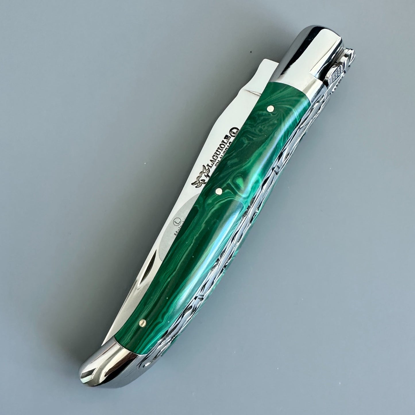 Closed Laguiole en Aubrac double-plated knife with green malachite handle and polished bolsters