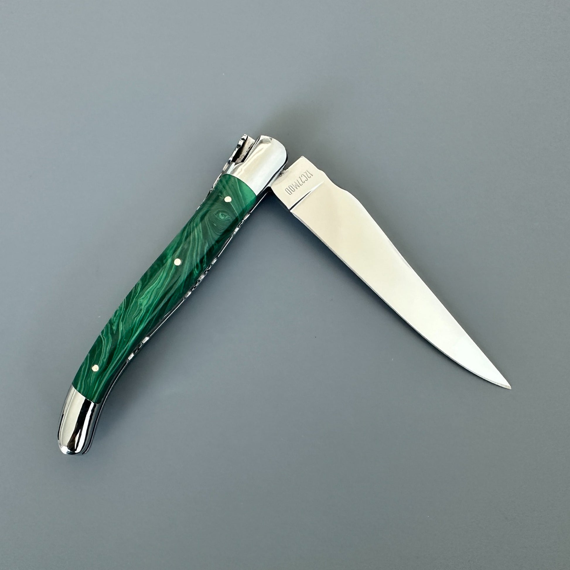 Reverse view of an open Laguiole en Aubrac double-plated knife with green malachite handle