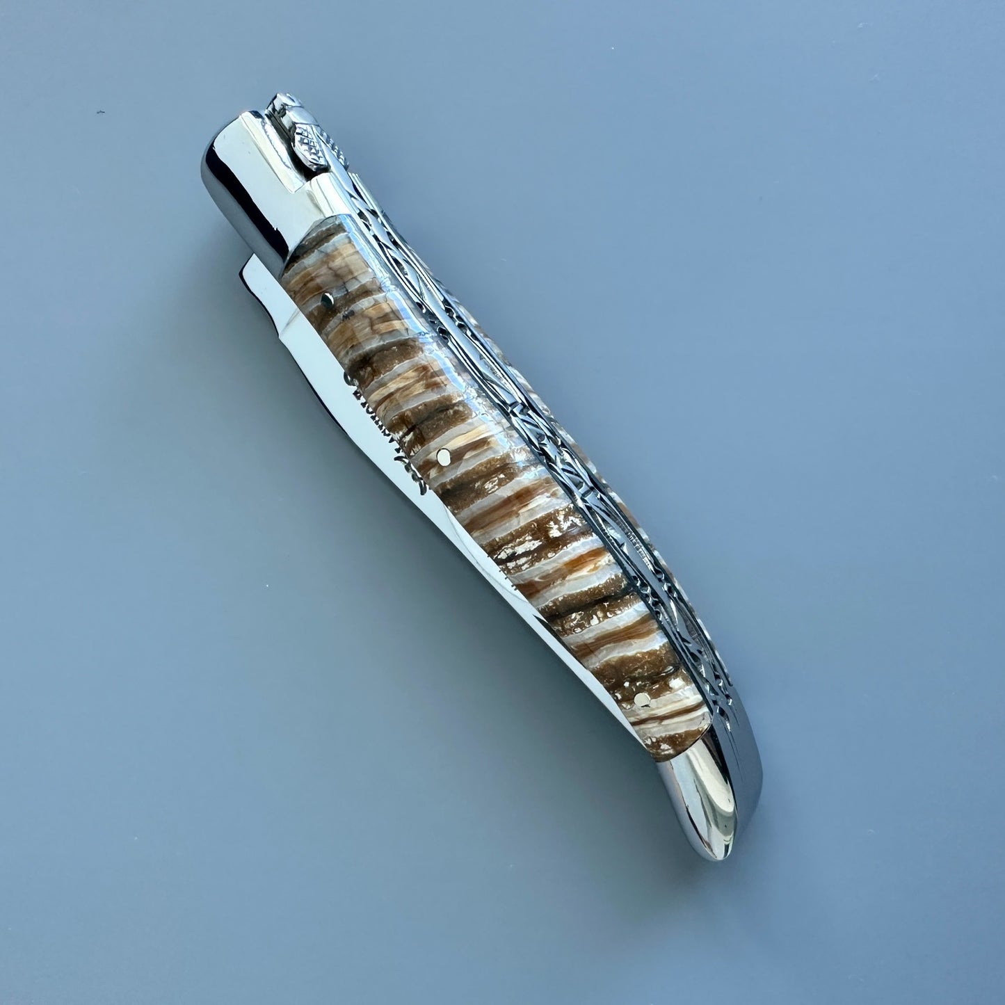 Closed Laguiole en Aubrac double-plated knife with brown and beige mammoth molar handle
