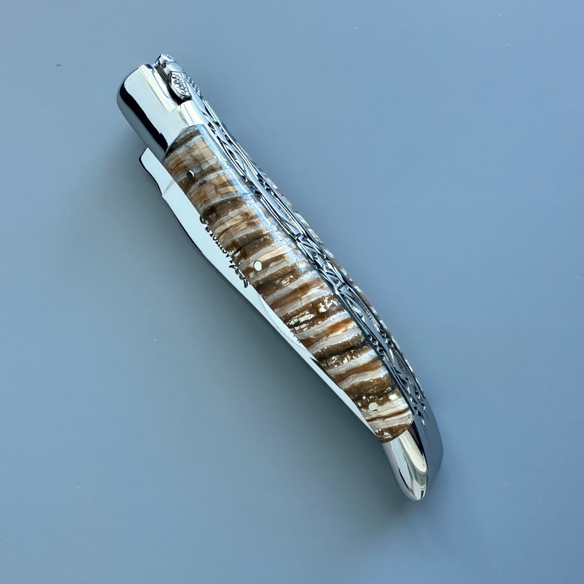 Closed Laguiole en Aubrac double-plated knife with brown and beige mammoth molar handle