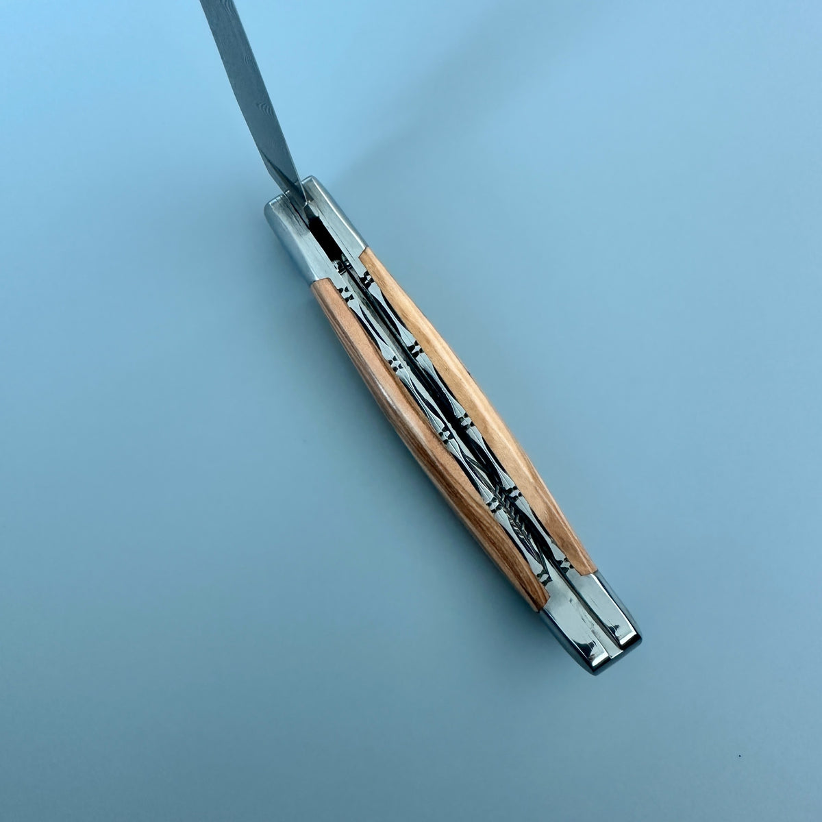 Inner spine of Laguiole en Aubrac double plated folding knife with Olive wood handle