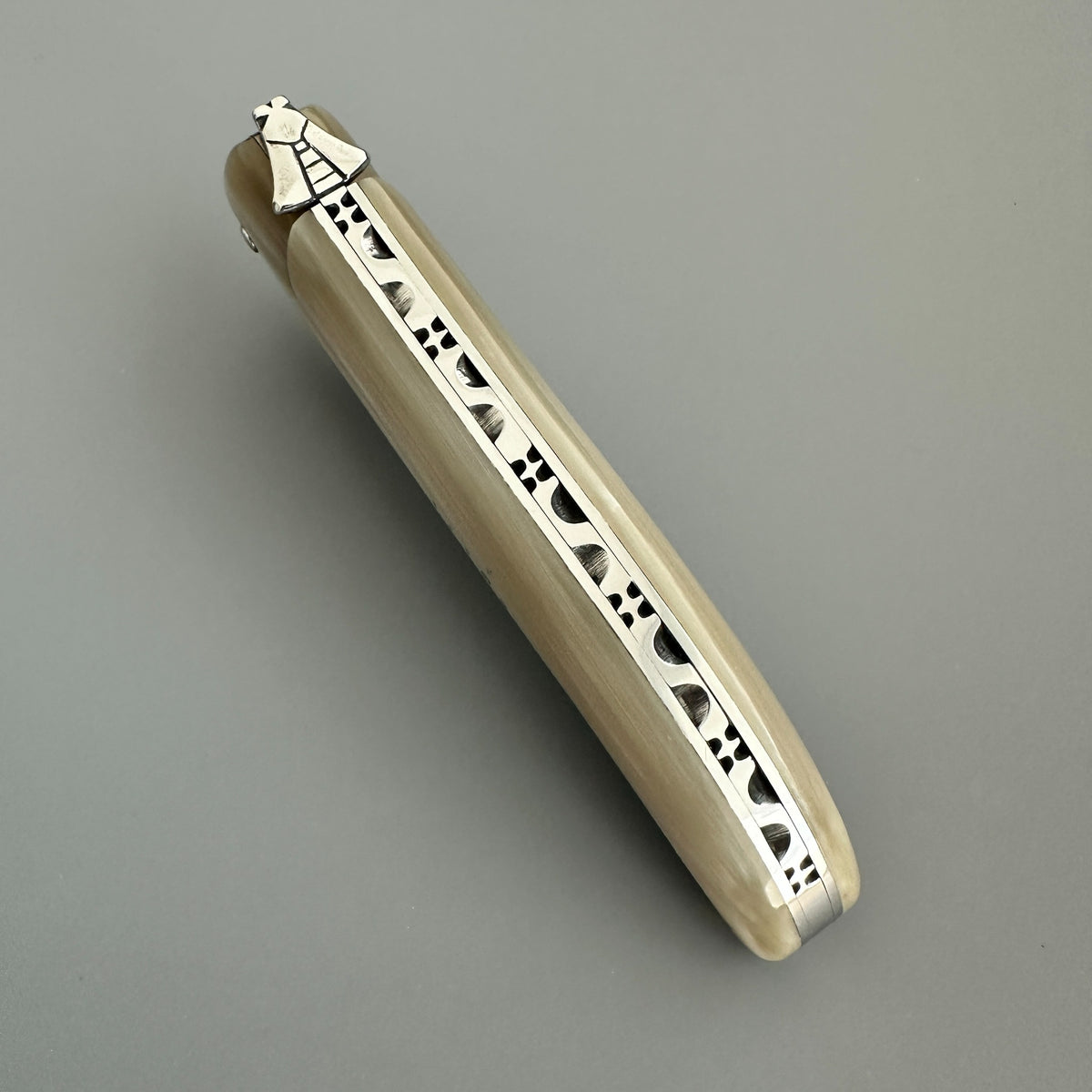Laguiole en Aubrac Hunting Knife  with Blonde Solid Horn Spine detail over a gray background