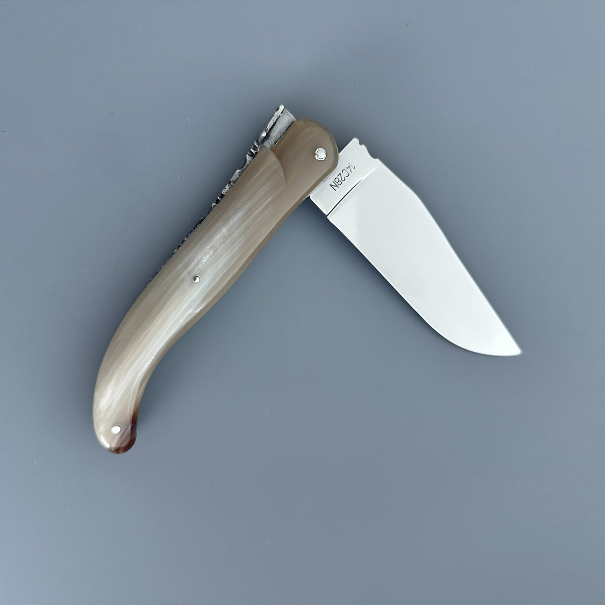 Reverse side of a partially opened Laguiole en Aubrac Hunting Knife with Blonde Solid Horn.