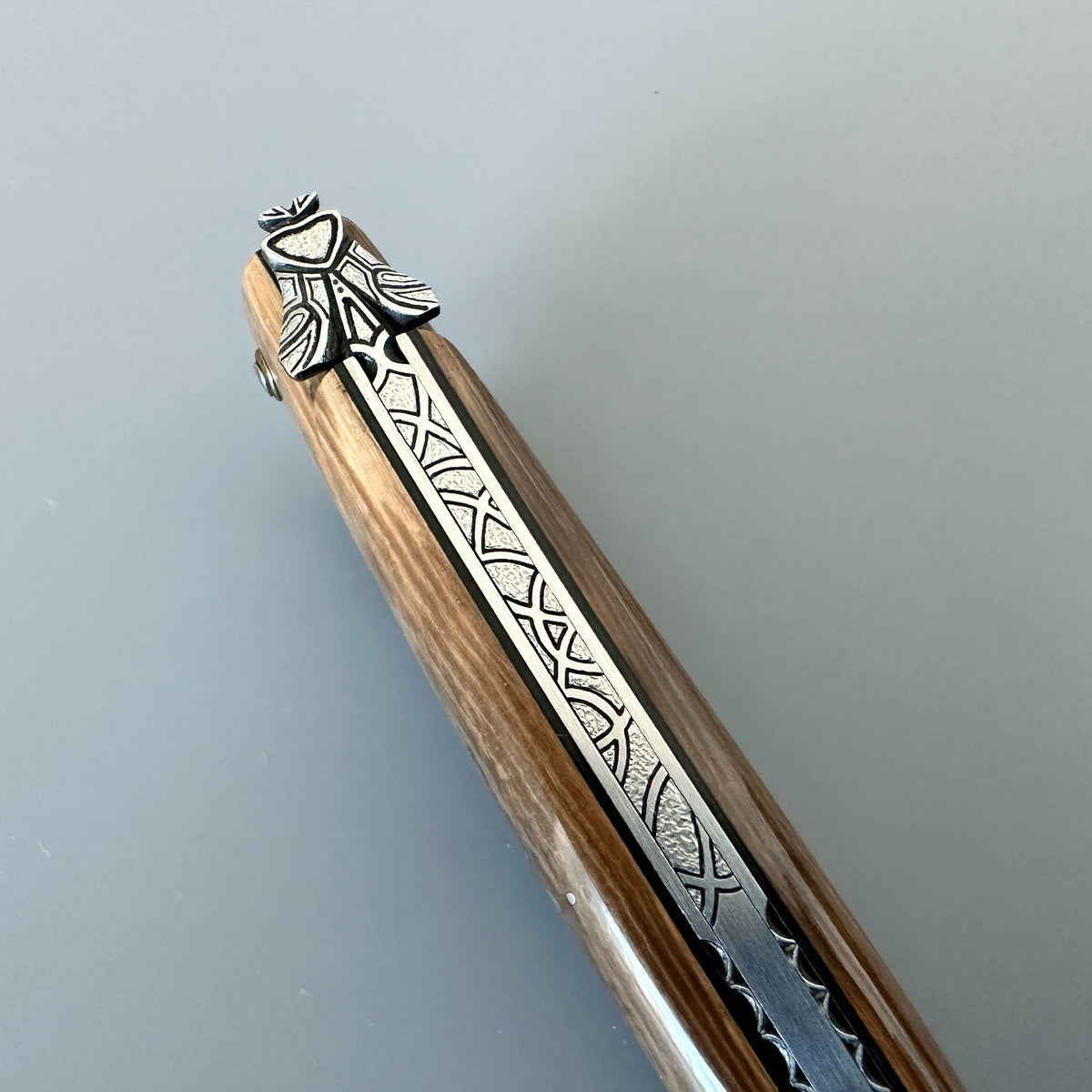 Close-up of the engraved bee and patterned spring on the Laguiole en Aubrac mammoth ivory folding knife