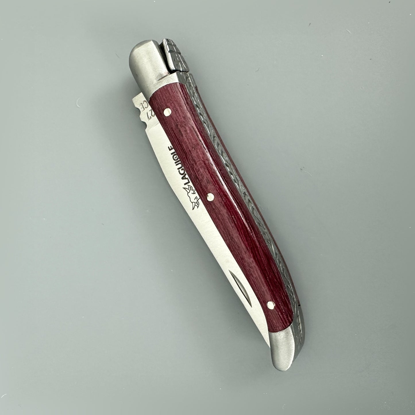 Closed Laguiole en Aubrac Mini Folding Knife displaying its Amaranth handle and blade engraving.