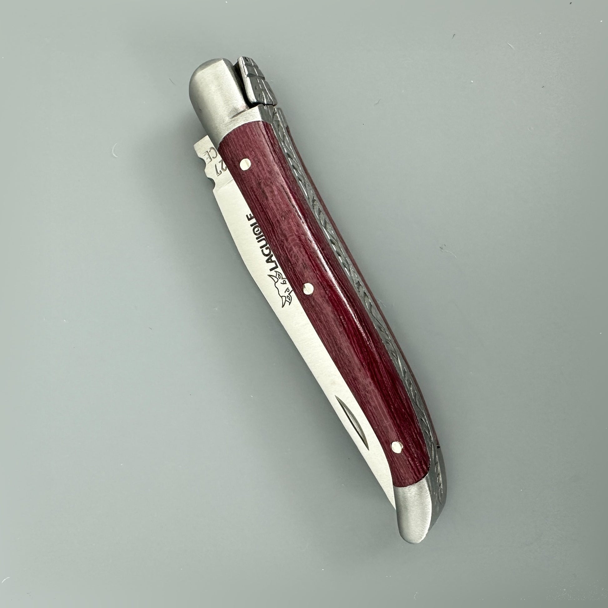 Closed Laguiole en Aubrac Mini Folding Knife displaying its Amaranth handle and blade engraving.