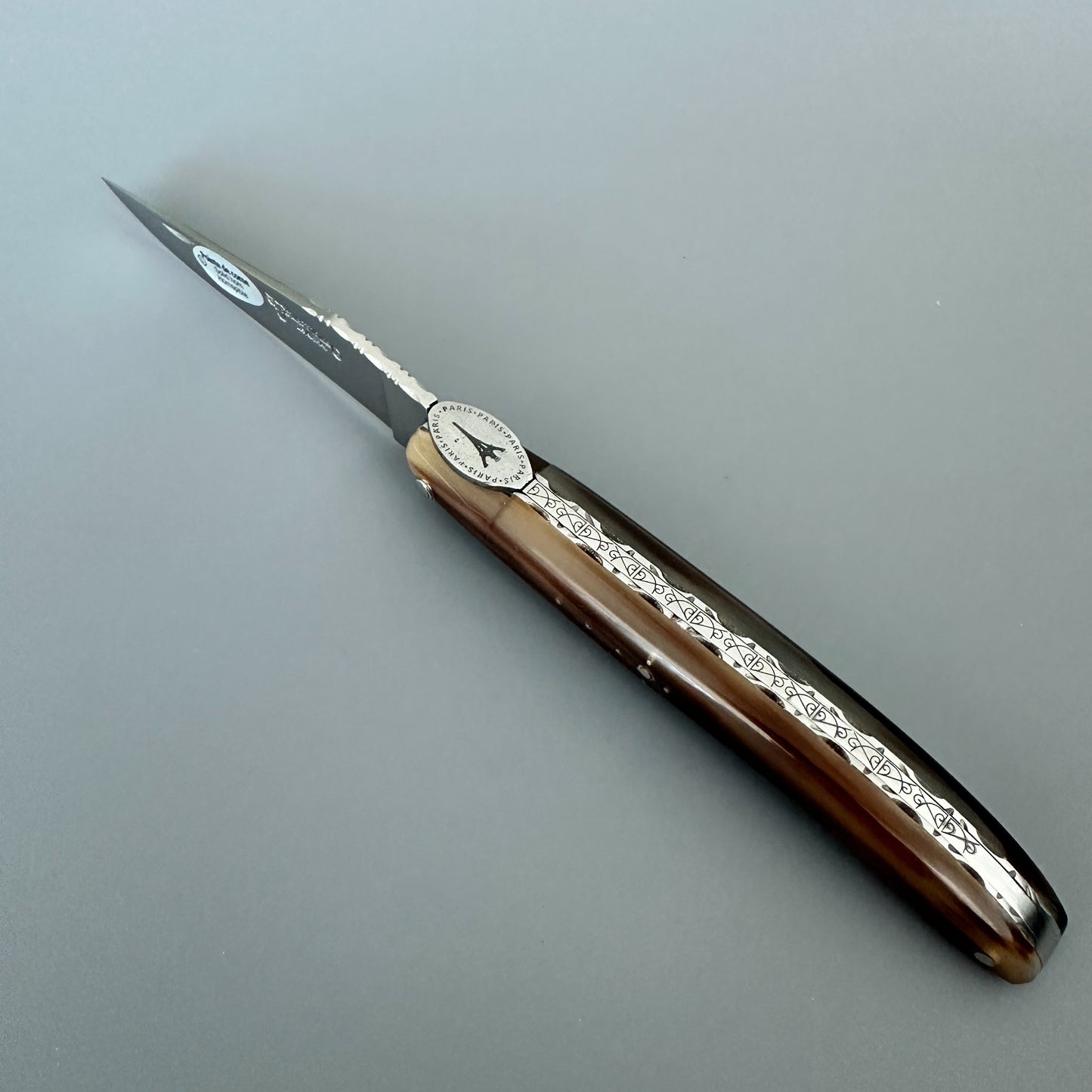 Spine view of a Laguiole en Aubrac Origine Tour Eiffel knife showing its solid horn handle