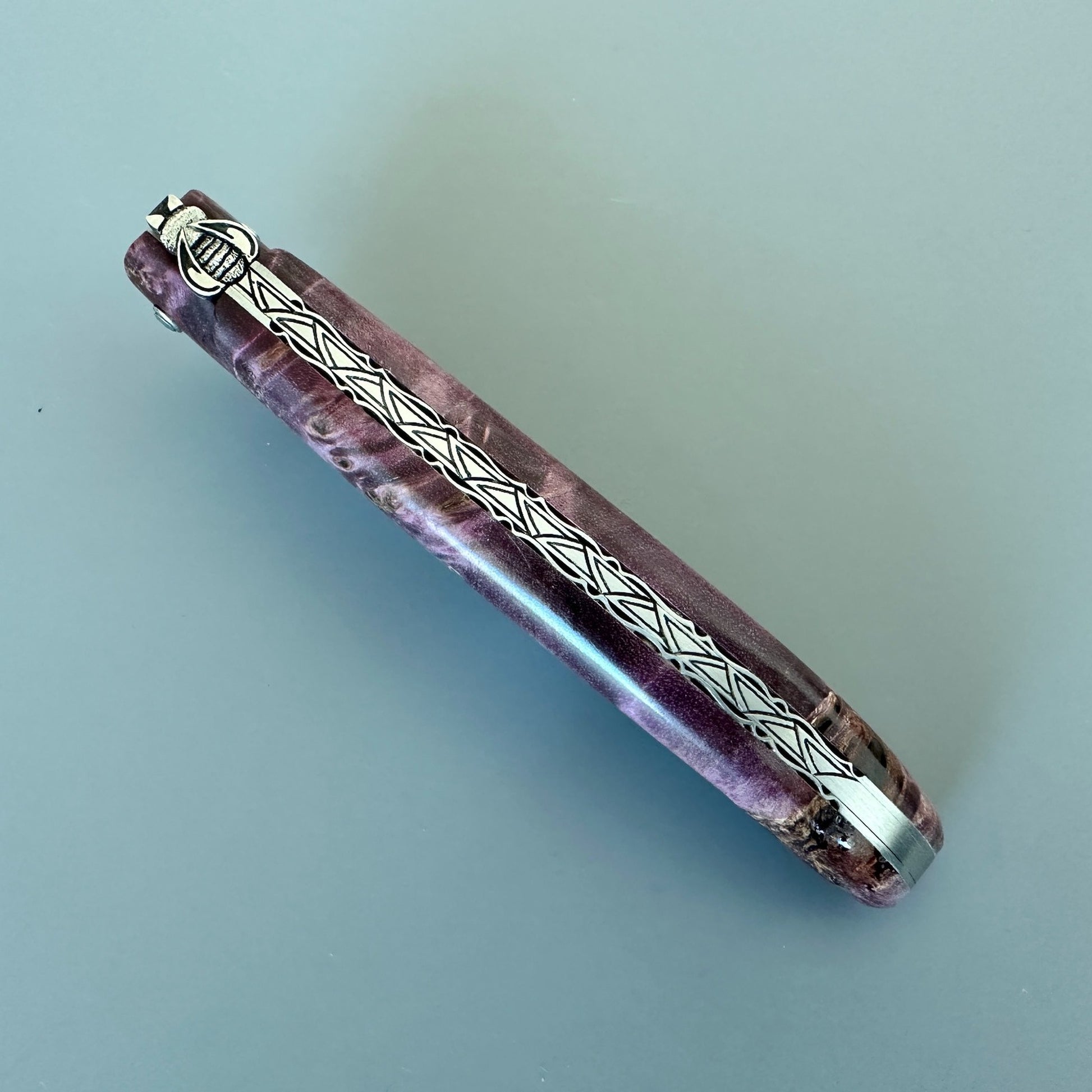 Closed Laguiole en Aubrac L0512WPH/FS-BP55 highlighting the decorated spine and Purple Poplar Burl handle.