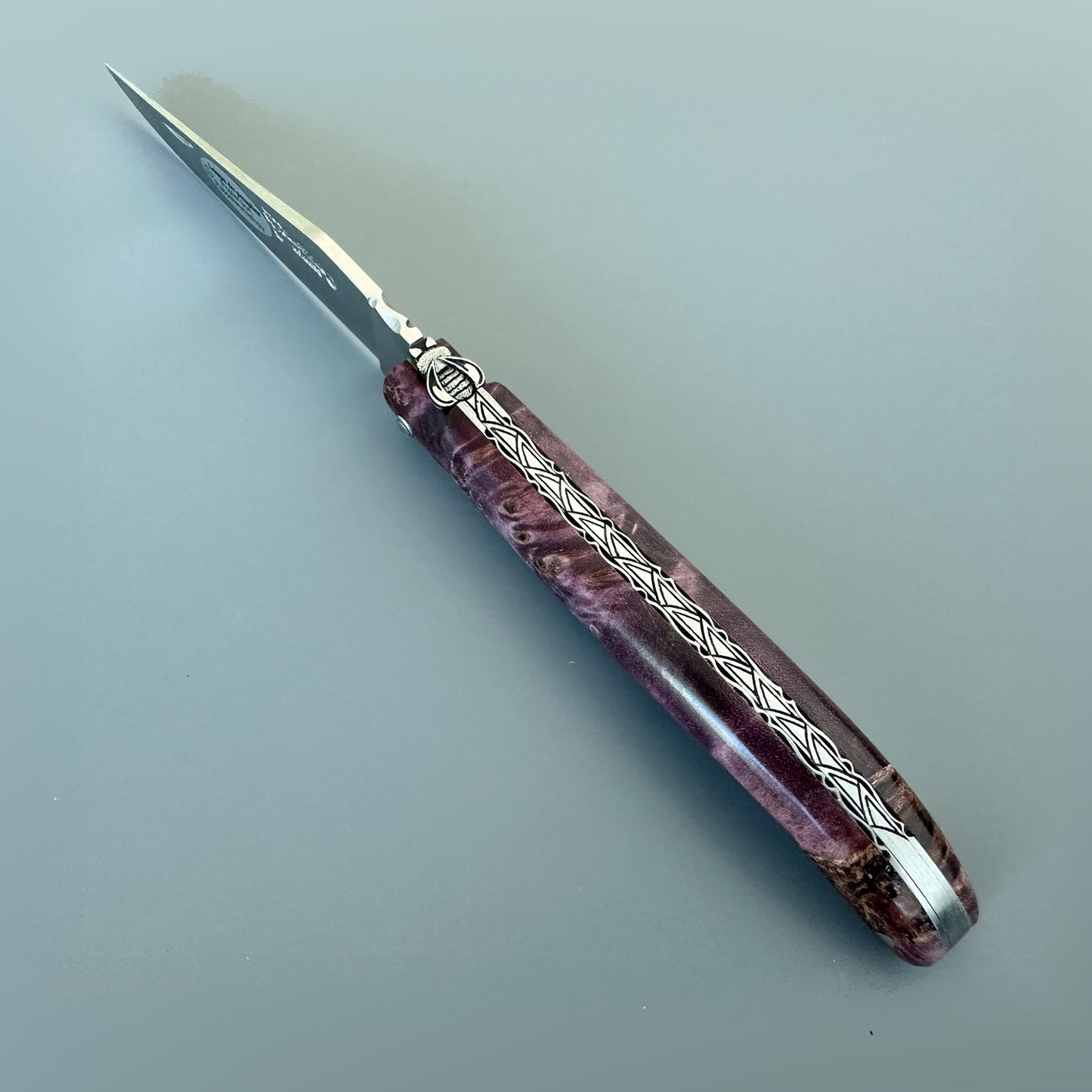 Open Laguiole en Aubrac L0512WPH/FS-BP55 showing its Purple Poplar Burl handle, sculpted bee and decorated spine.