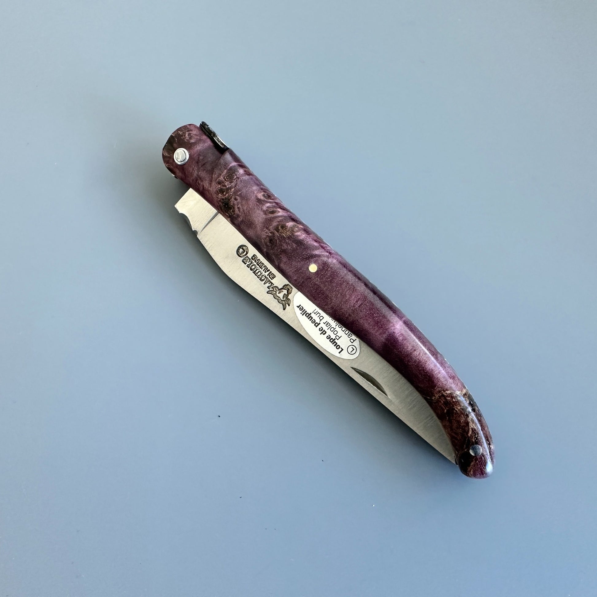 Closed Laguiole en Aubrac L0512WPH/FS-BP55 highlighting the decorated spine and Purple Poplar Burl handle.