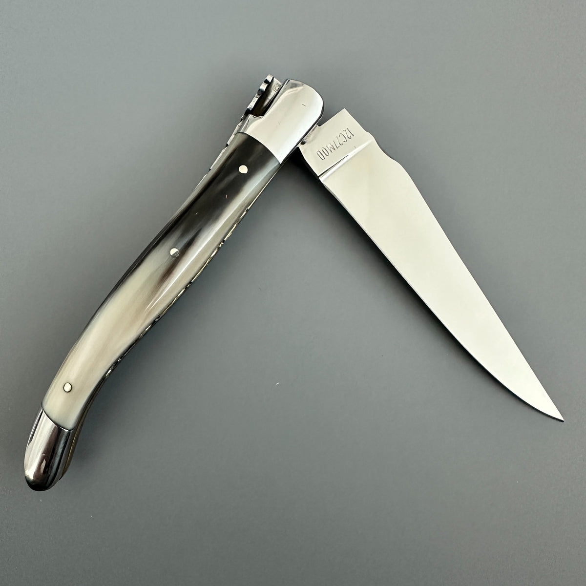 Reverse side of Laguiole en Aubrac double-plated pocket knife with a solid horn handle and brass inner spine