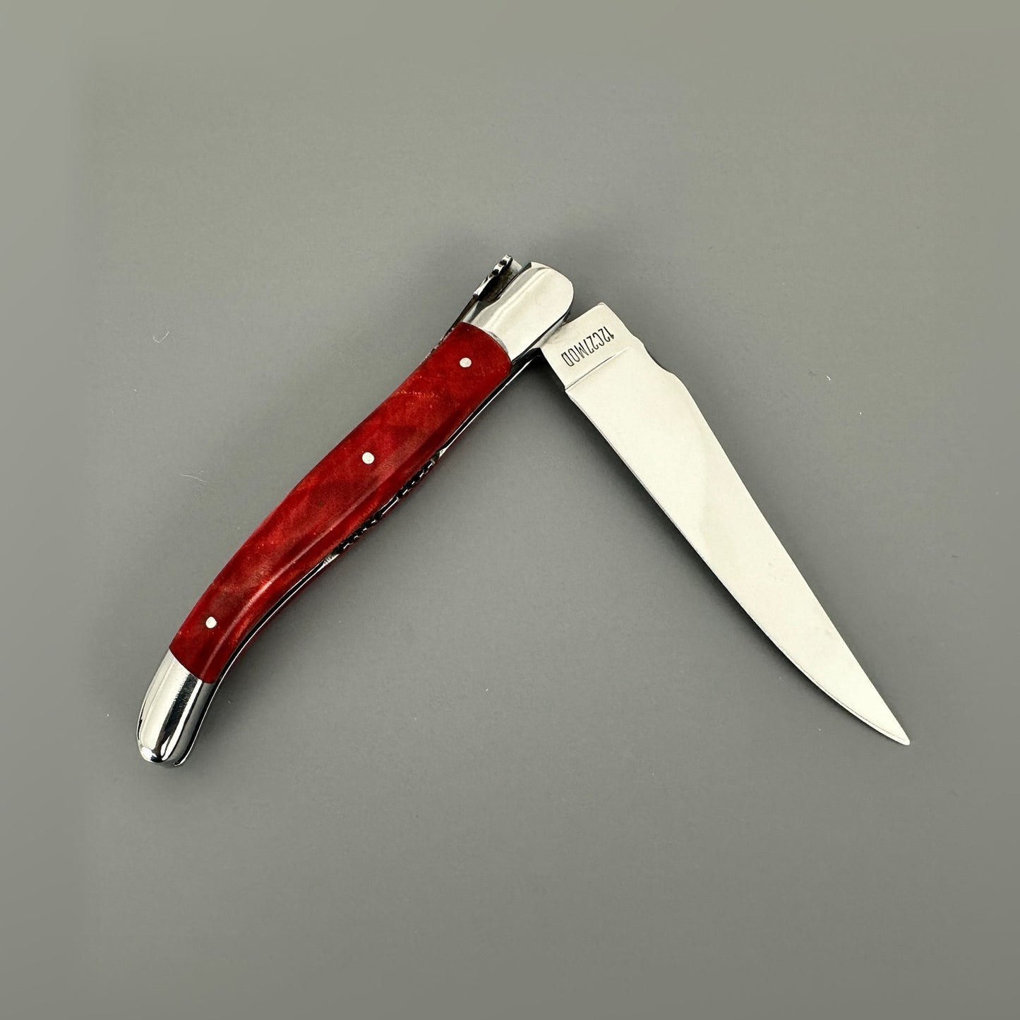 Reverse view of the open Laguiole en Aubrac knife with a stabilized red poplar handle.